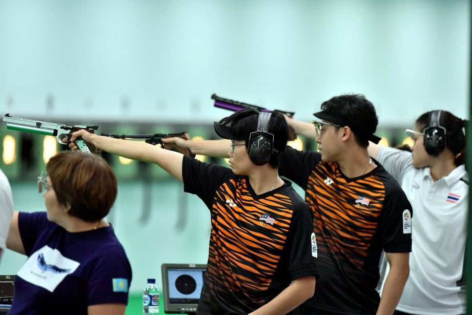 JOHNATHAN Wong Guanjie (dua, kanan) dan Joseline Cheah Lee Yean (dua, kiri) beraksi pada 10 meter Air Pistol campuran. FOTO Bernama