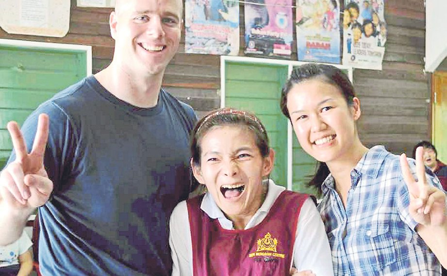 CATHY (tengah) bergambar dengan pelawat asing yang berkunjung ke Pusat Seri Mengasih, Kota Kinabalu.