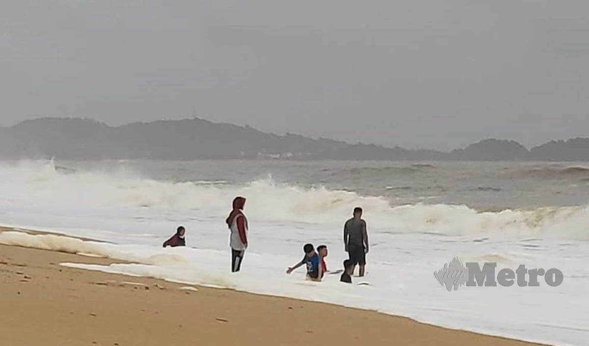PENGUNJUNG mandi sambil bermain ombak besar di pantai Sura Tengah biarpun pantai itu sudah meragut ramai nyawa. FOTO  Rosli Ilham