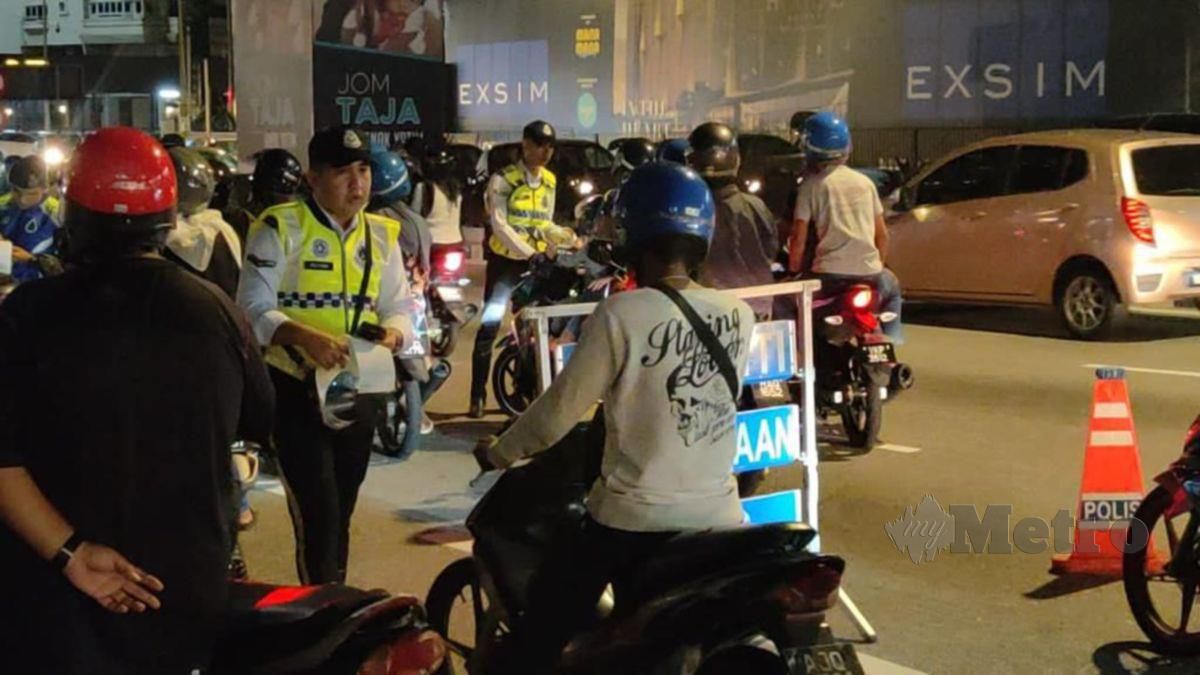 ANGGOTA polis trafik menjalankan pemeriksaan dalam Op HUU Polis Kuala Lumpur di sekitar ibu negara, semalam. FOTO ihsan JSPT