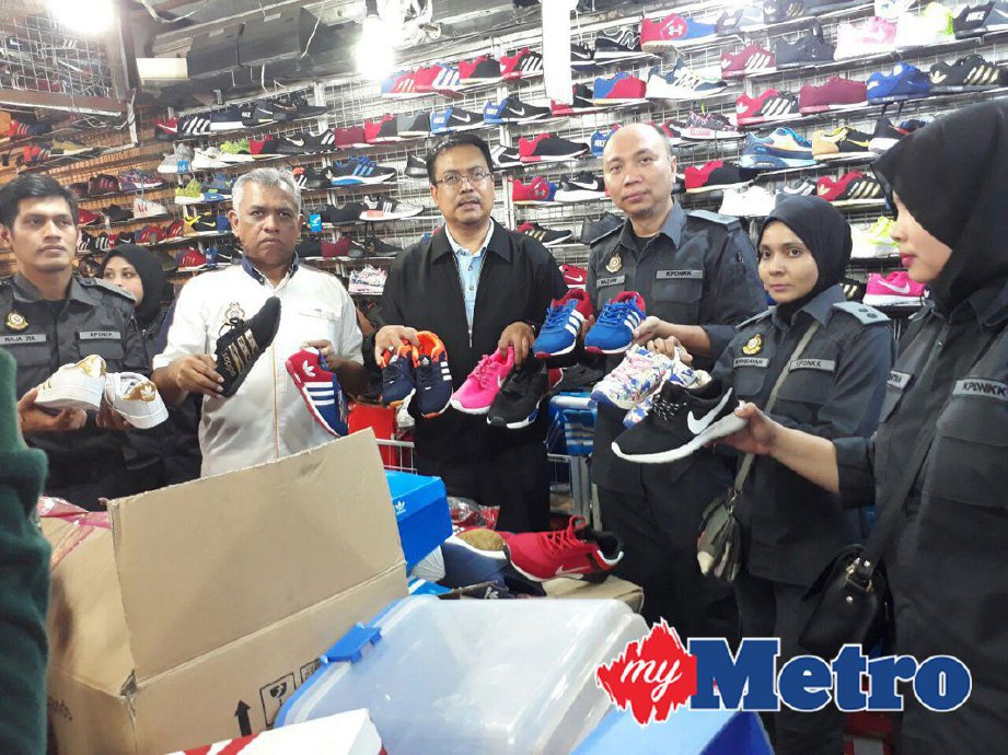Khairul (tiga dari kiri) dan anggotanya selepas merampas pelbagai kasut tiruan di sebuah stor simpanan dalam operasi di Pasar Borong Pandan malam ini. FOTO Mohd Sabran Md sani