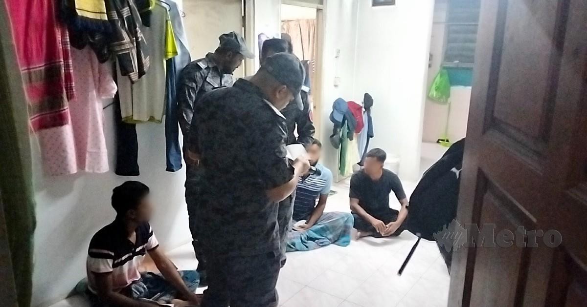 PENGUAT KUASA imigresen menjalankan pemeriksaan terhadap warga asing yang menyewa di Rumah Pangsa Bercham. FOTO Muhammad Zulsyamini Sufian Suri