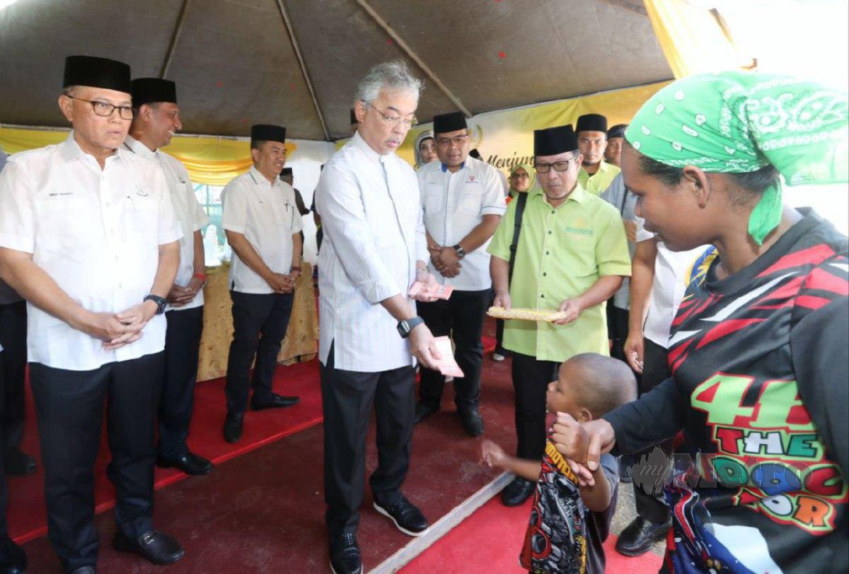 AL SULTAN Abdullah menyampaikan sumbangan kepada kanak-kanak Orang Asli di Rumah Transit Kampung Orang Asli Sungai Ruil. FOTO Mohd Rafi Mamat