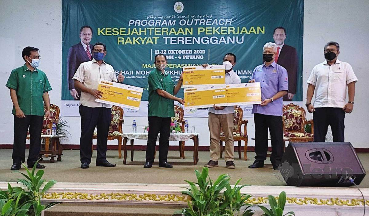 MOHD Nurkhuzaini (tiga, kiri) menyerahkan replika cek insentif kepada pemohon yang berjaya mendapat kerja pada Program “Outreach” Kesejahteraan Pekerjaan Rakyat Negeri Terengganu Sesi 1 2021, di Gong Kemuntong, Jertih. FOTO Nurul Fatihah Sulaini