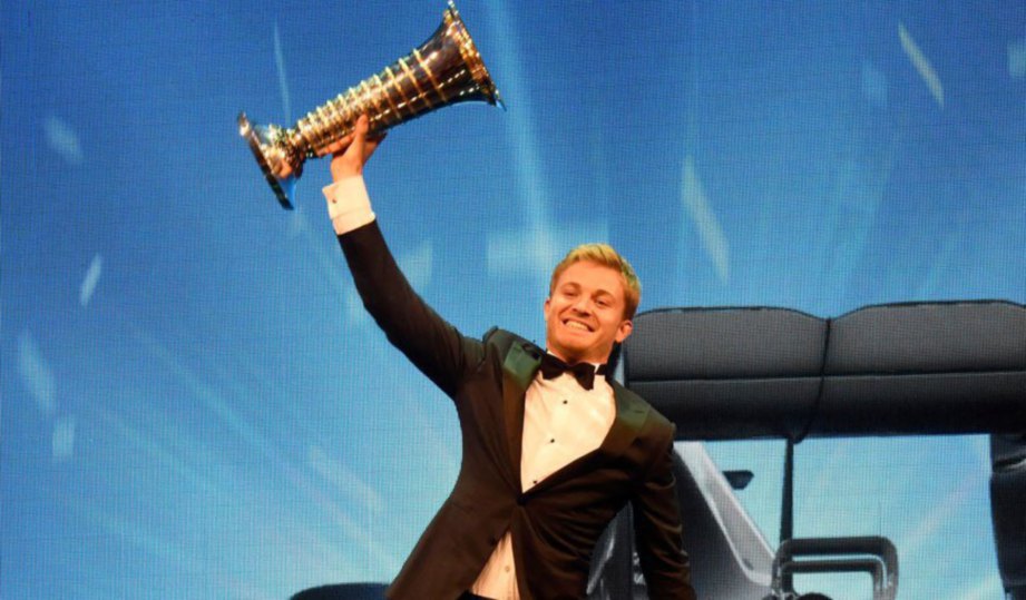 ROSBERG gembira menjulang trofi juara dunia Formula Satu.