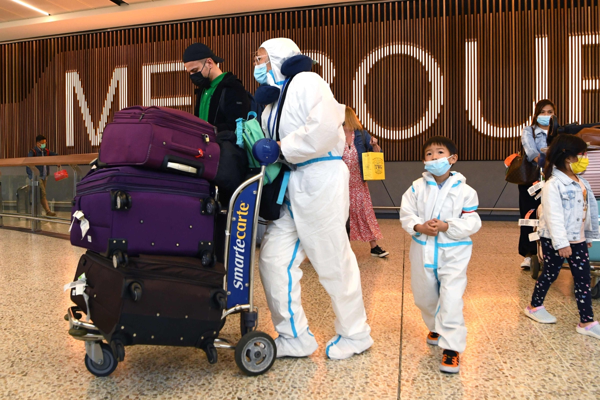 PENGEMBARA antarabangsa memakai pakaian perlindungan diri ketika tiba di Lapangan Terbang Tullamarine, Melbourne. FOTO AFP 