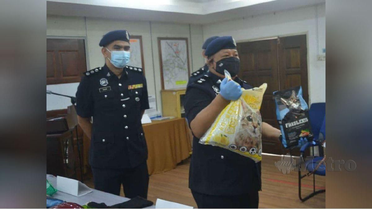AZHAR menunjukkan makanan kucing yang dirampas selepas tertangkap Geng Pak Su. FOTO ihsan polis 