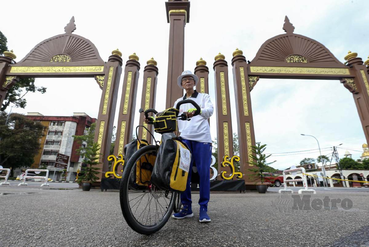 PAK Wan bersama basikal yang akan digunakan bagi kayuhan solo mengelilingi Semenanjung Malaysia buat kali ketujuh yang bermula hari ini di pekarangan Mabna-MBI Kompleks Kota Darulnaim. FOTO Nik Abdullah Nik Omar