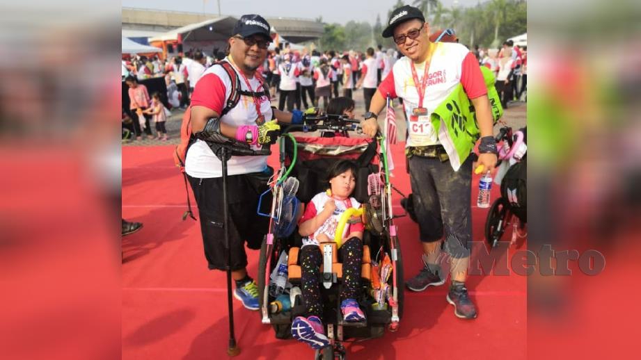 Wira (kanan) bersama anaknya (atas kerusi roda khas) dan peserta OKU yang menyertai Larian Selangor Corporate Colour 2019 di Stadium Shah Alam hari ini. Foto Roslin Mat Tahir