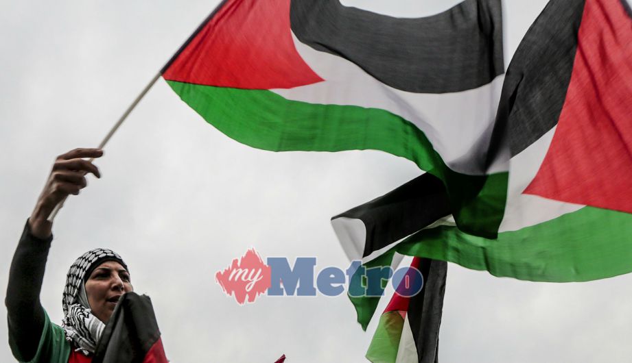 Seorang wanita mengibarkan bendera Palestin semasa perhimpunan membantah pengisytiharan Baitulmuqaddis sebagai ibu negara Israel oleh Presiden Amerika Syarikat, Donald Trump. Perhimpunan diadakan di Beirut, Lebanon, pada 19 Disember lalu. FOTO Agensi