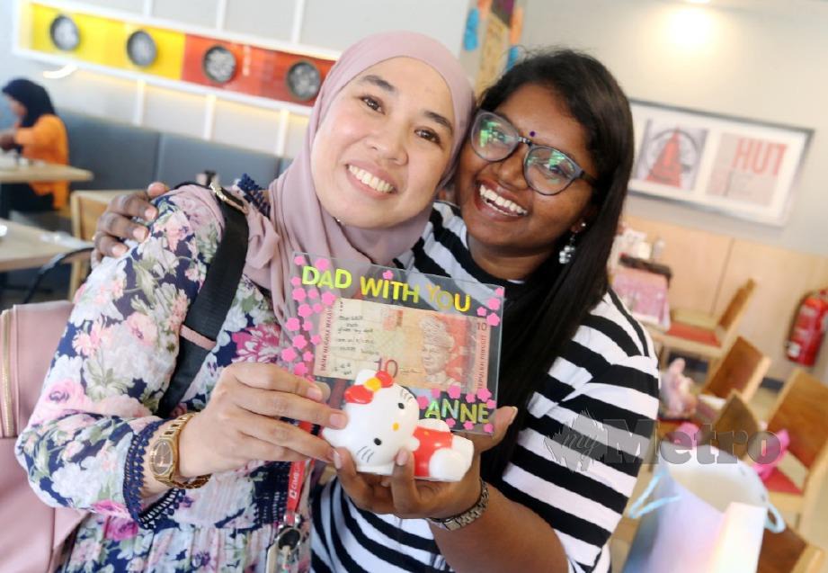  NORHAIZALIFA bersama Anne menunjukkan not RM10 yang mempertemukan mereka. FOTO Rasul Azli Samad 