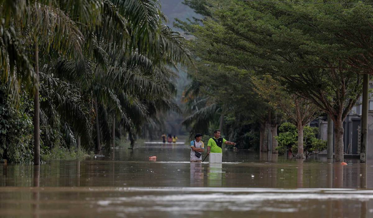 BEBERAPA penduduk setempat meredah banjir dari kediaman ke Pusat Pemindahan Sementara (PPS) ketika tinjauan di Seri Medan, Batu Pahat. FOTO BERNAMA 