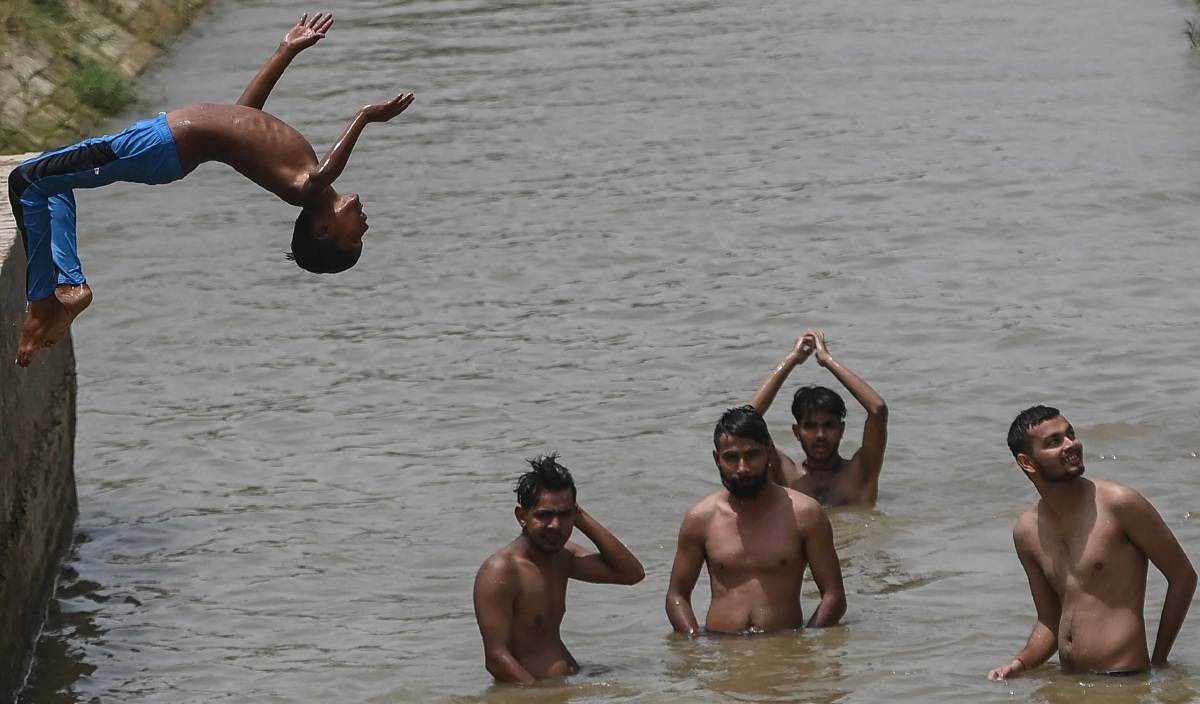 SEORANG kanak-kanak melakukan lompatan ke dalam terusan ketika cuaca panas di Sri Ganganagar. FOTO AFP