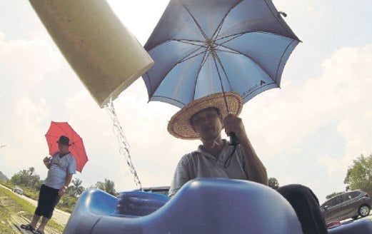 GUNA payung dan topi untuk melindungi diri daripada cuaca panas.