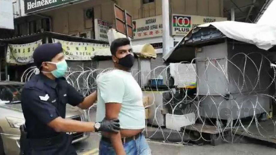 LELAKI warga asing yang cuba melarikan diri dari kawasan diperketatkan kawalan di Jalan Pasar Pudu, Kuala Lumpur, hari ini, berjaya ditahan anggota polis bertugas. FOTO Nurul Hidayah Bahaudin