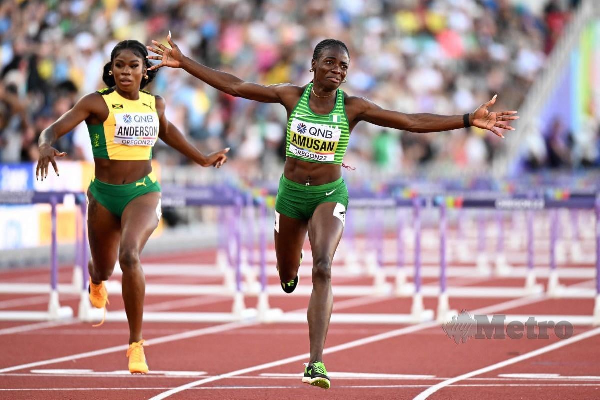 TOBI (kanan) memenangi perlumbaan 100m lari berpagar. FOTO AFP