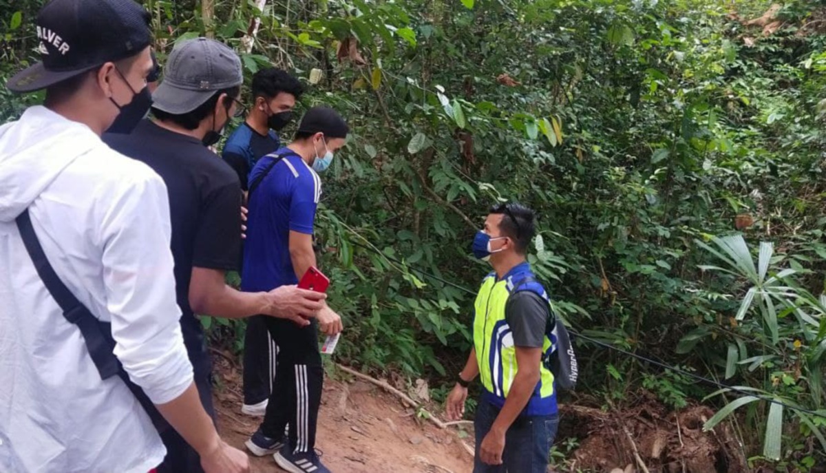 Anggota polis memantau pengunjung yang mendaki Bukit Panau dalam penugasan pemantauan Perintah Kawalan Pergerakan (PKP). FOTO IHSAN POLIS