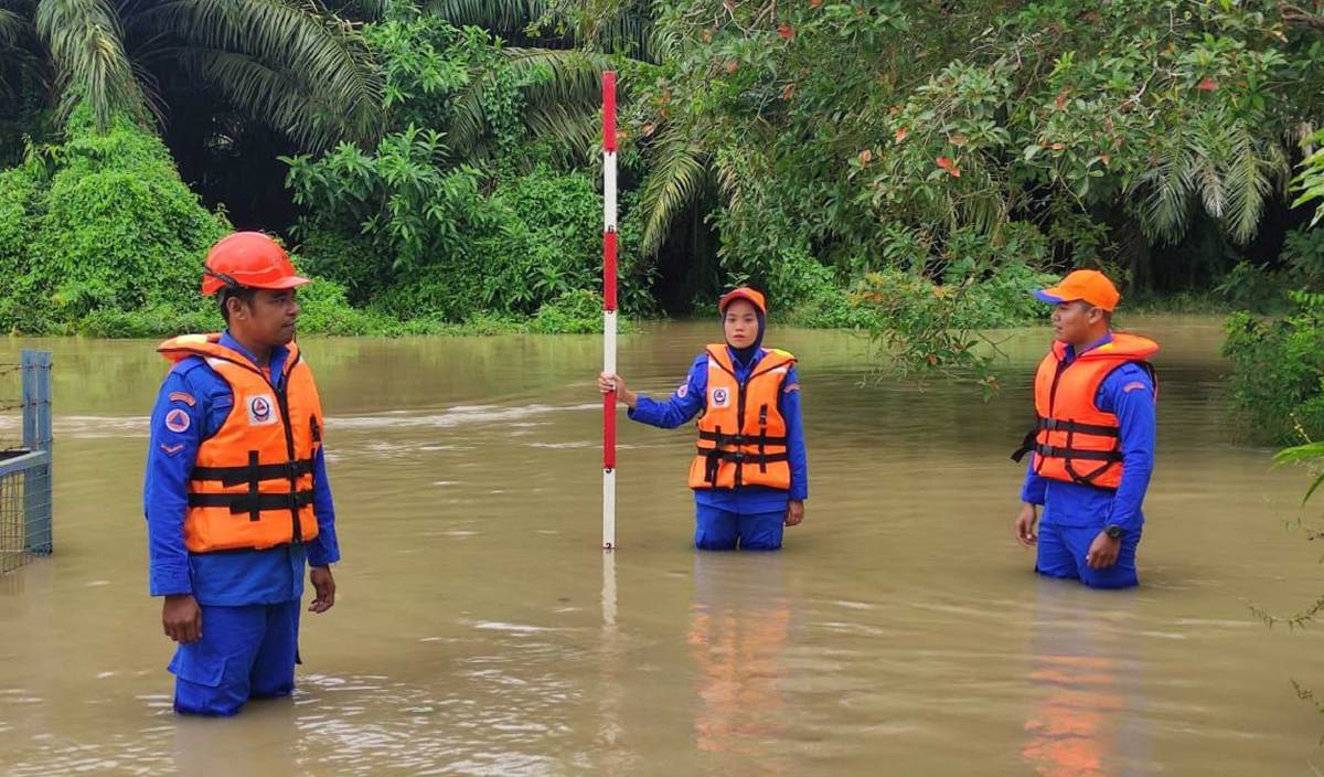 ANGGOTA APM Pendang melakukan pemantauan paras air yang semakin meningkat di daerah itu berikutan paras air Sungai Pendang sudah melepasi tahap amaran. FOTO Ihsan APM