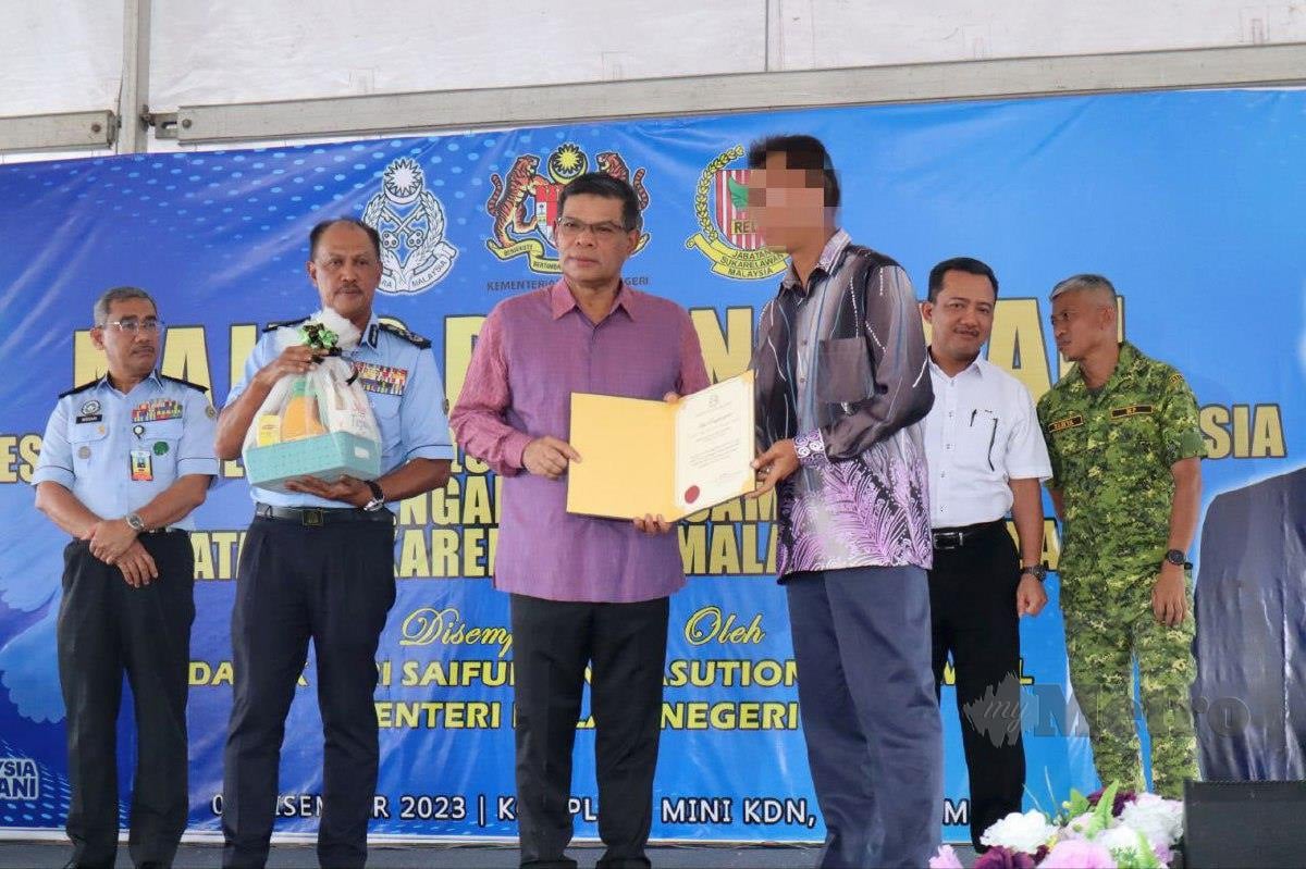 SAIFUDDIN (tiga kiri) menyerahkan sijil penghargaan kepada seorang bekas banduan yang sudah bebas sepenuhnya selepas menjalani Sistem Parol. FOTO Muhamad Lokman Khairi