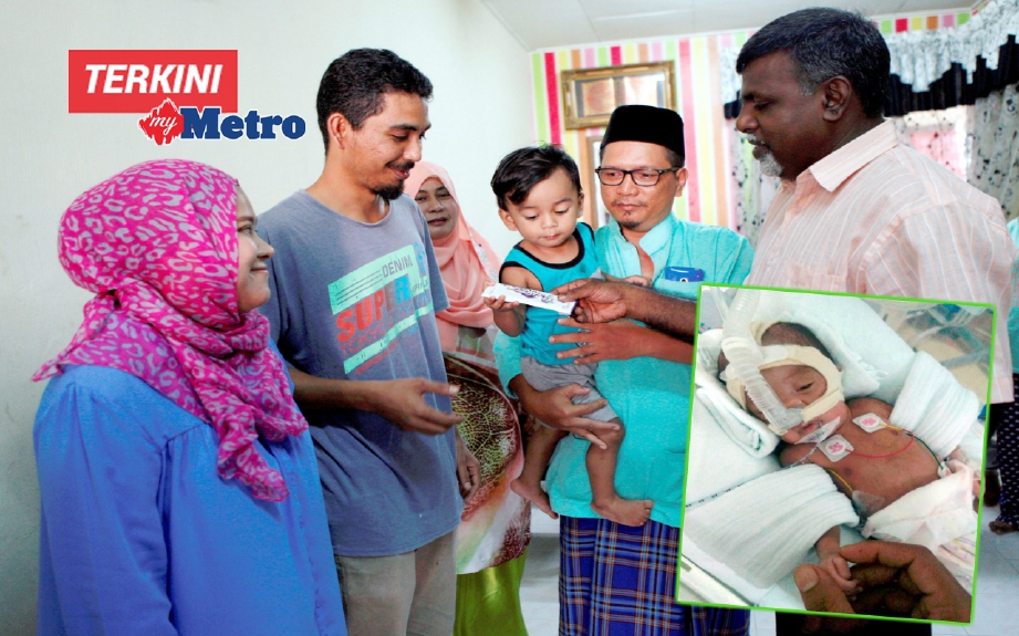 Abdul Aziz (kanan) menyampaikan sumbangan kepada Mohd Noor Izham dan isterinya, Nur Emalina. FOTO Amir Irsyad Omar