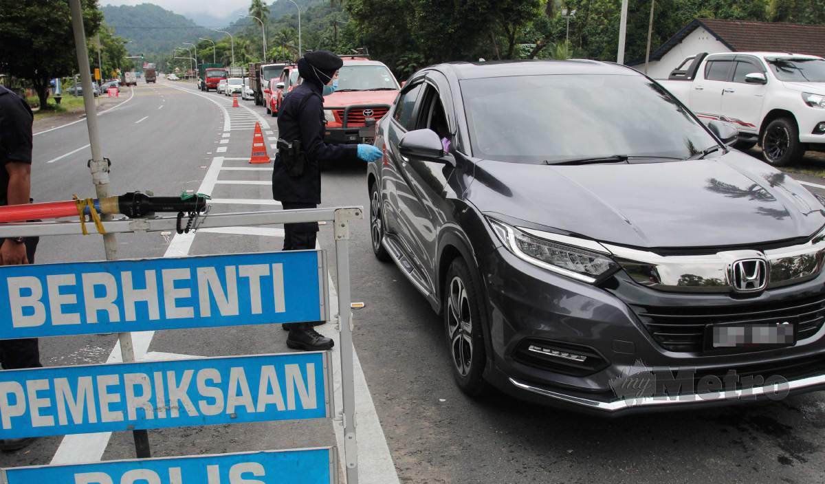 ANGGOTA Polis Diraja Malaysia (PDRM) membuat pemeriksaan di Sekatan Jalan Raya (SJR) Bukit Yong di sempadan Kelantan dan Terengganu pada hari pertama Perintah Kawalan Pergerakan Bersyarat (PKPB) yang bermula hari ini. FOTO Nik Abdullah Nik Omar