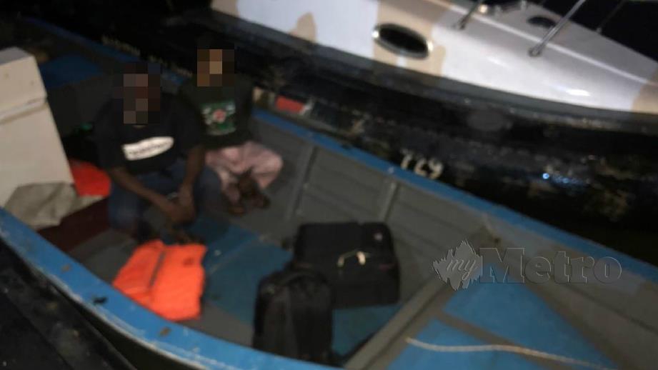 Dua lelaki warga asing yang ditahan ketika cuba menyeludup masuk ke negara ini. FOTO Ihsan Maritim Malaysia 