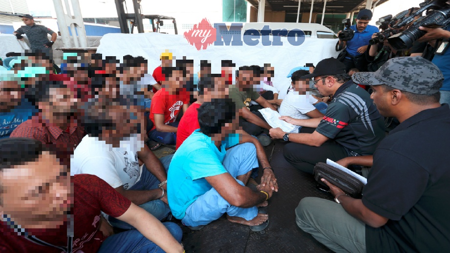 MUSTAFAR (duduk dua dari kanan) melihat salinan pengenalan diri pekerja asing dalam operasi penguat kuasaan selepas tamat Program 3+1 di kilang pembuatan sarung tangan di Sepang, hari ini. FOTO Ahmad Irham Mohd Noor