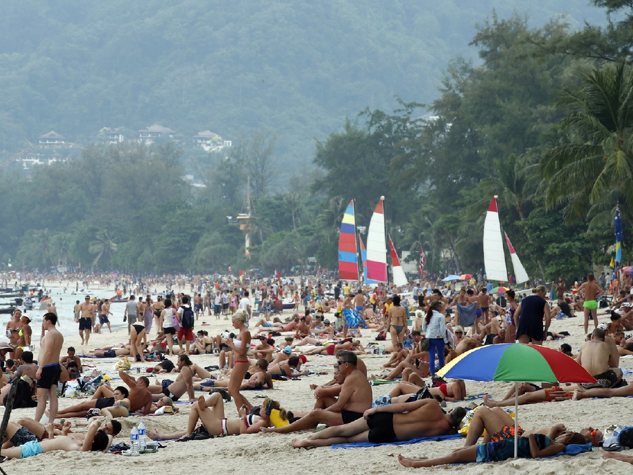 Pelancong yang memenuhi Pantai Patong, di Phuket, Thailand, boleh dikenakan denda RM12,757 jika melanggar larangan merokok di pantai.- Foto EPA