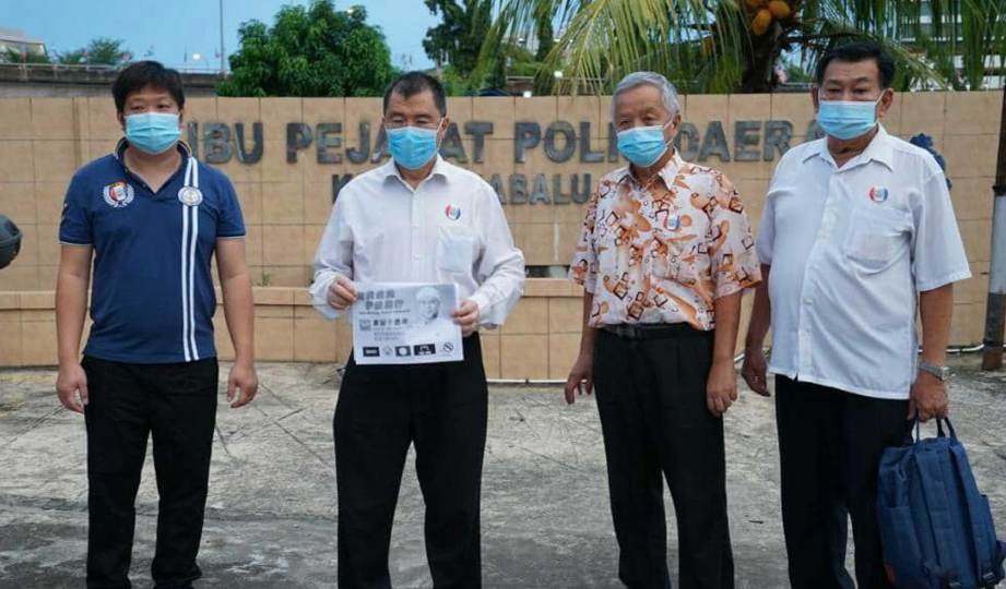 DR Yee Moh Chai (dua kiri), membuat laporan polis di IPD Kota Kinabalu selepas poster gambarnya dimanipulasi untuk membangkitkan isu sensitif. FOTO Ihsan PBS
