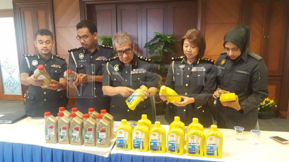 Timbalan Pengarah Cawangan Operasi Khas KPDNHEP, Rosli Ahmad menunjukkan minyak pelincir yang dirampas. FOTO Siti A’isyah Sukaimi