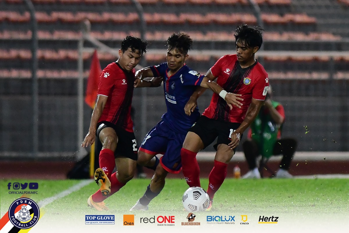 Pemain skuad Projek FAM-MSN cuba menghalang pemain PDRM FC (tengah) dalam saingan Liga Perdana semalam. FOTO Ihsan PDRM FC