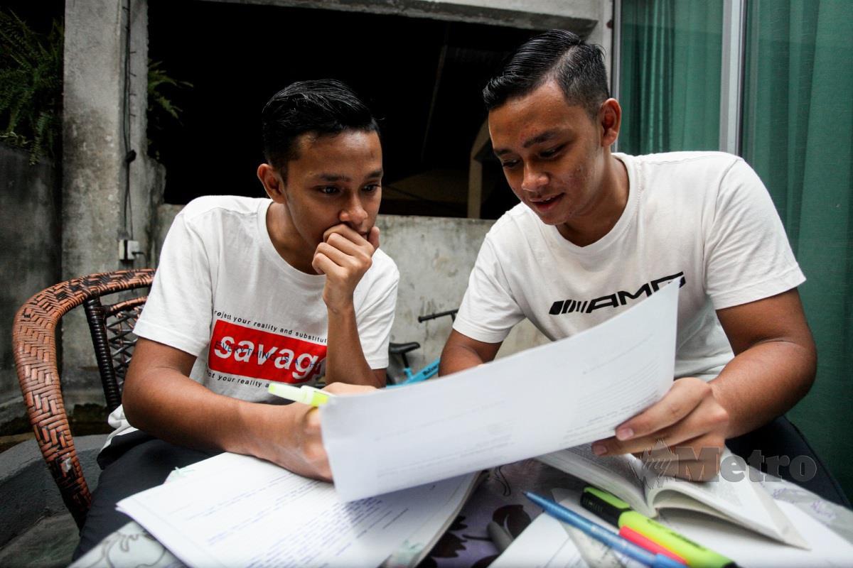 Muhd Iman (kanan) dan adiknya Muhd Amin sedang mengulangkaji pelajaran sebagai persiapan peperiksaan Sijil Pelajaran Malaysia (SPM) di rumah mereka di Tambun. FOTO BALQIS JAZIMAH ZAHARI