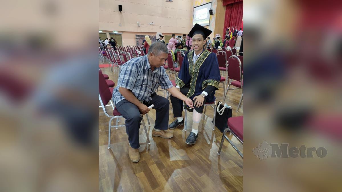 MUHAMMAD Iqbal Aiman Manaf, bersama ayahnya menunjukkan kaki palsunya ketika Majlis Konvokesyen Pertama Politeknik Besut, Terengganu, di sini, hari ini. FOTO NURUL FATIHAH SULAINI