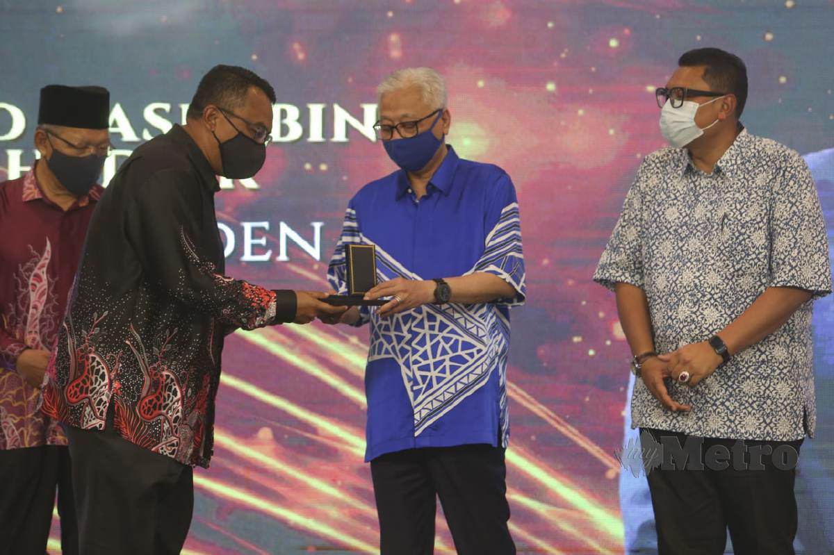 ISMAIL Sabri menyampaikan anugerah Pingat Jasa Cemerlang kepada penerima sambil diperhatikan Ahmad (kiri) dan Mohd Syahbuddin. FOTO Nik Abdullah Nik Omar