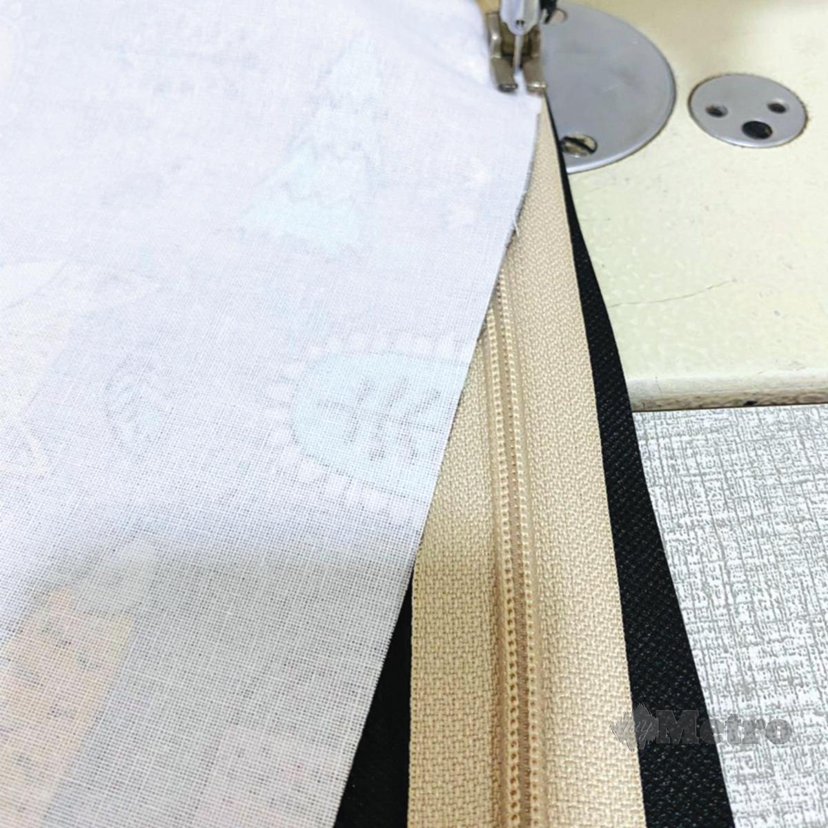 CANTUMKAN kain corak, zip dan kain lining dengan jahitan. 