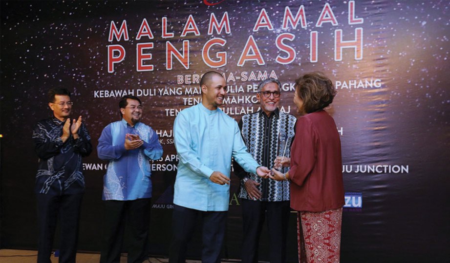 KAMISAH menerima penghargaan Anugerah Tan Sri Megat Junid daripada Tengku Amir.
