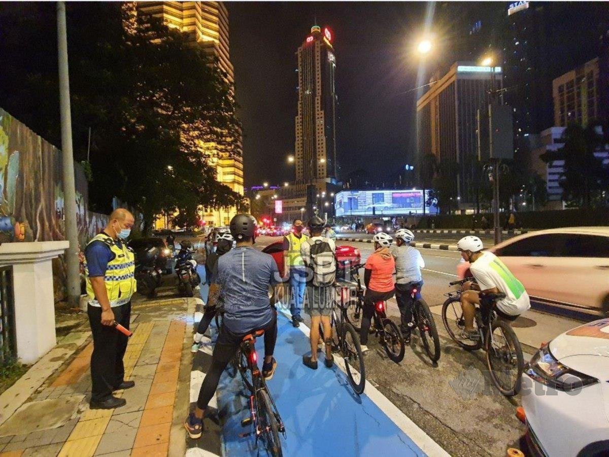 ANGGOTA JSPT menjalankan pemeriksaan terhadap aspek keselamatan pengayuh basikal di ibu kota. FOTO ihsan polis