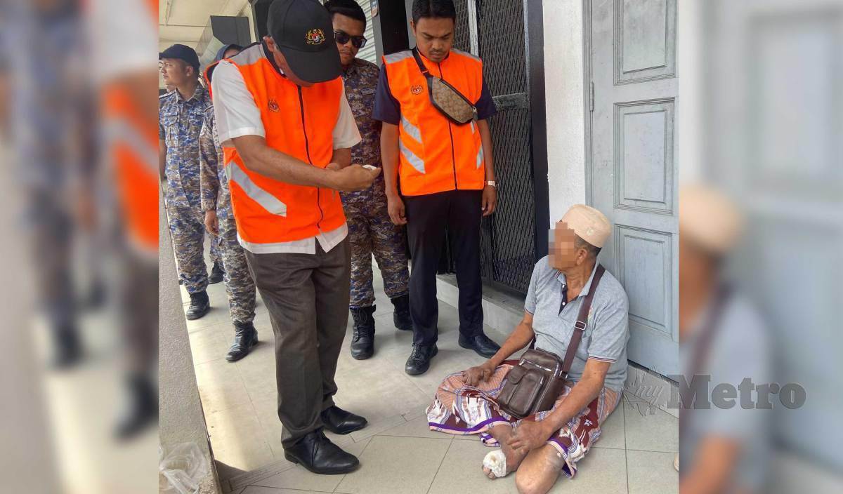ANGGOTA penguat kuasa memeriksa pengemis warga asing yang juga berstatus OKU fizikal ketika Operasi Bersepadu Banteras Pengemis dan Gelandangan di Kota Bharu. FOTO Hazira Ahmad Zaidi