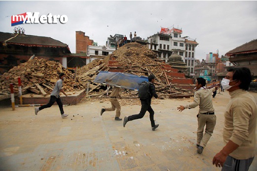 Sukarelawan berlari membawa pengusung selepas dimaklumkan ada mayat ditemui di Kathmandu. FOTO AP