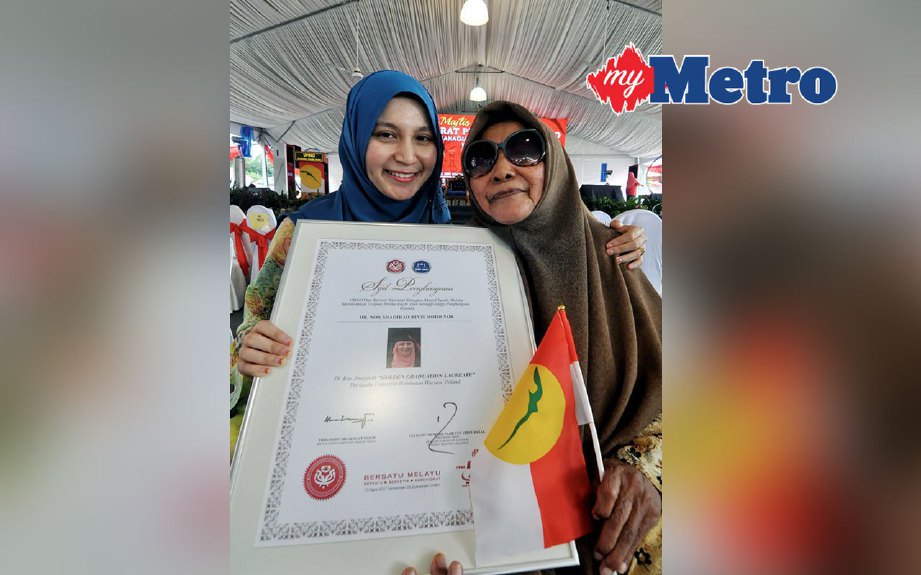 Dr Nor Syahirah bersama neneknya, Zainon Puteh, 81,  memegang plak penghargaan disampaikan Perdana Menteri Datuk Seri Najib Razak pada Majlis Perasmian Penutup Mesyuarat Perwakilan UMNO Bahagian Masjid Tanah, hari ini. FOTO MUHAMMAD HATIM AB MANAN