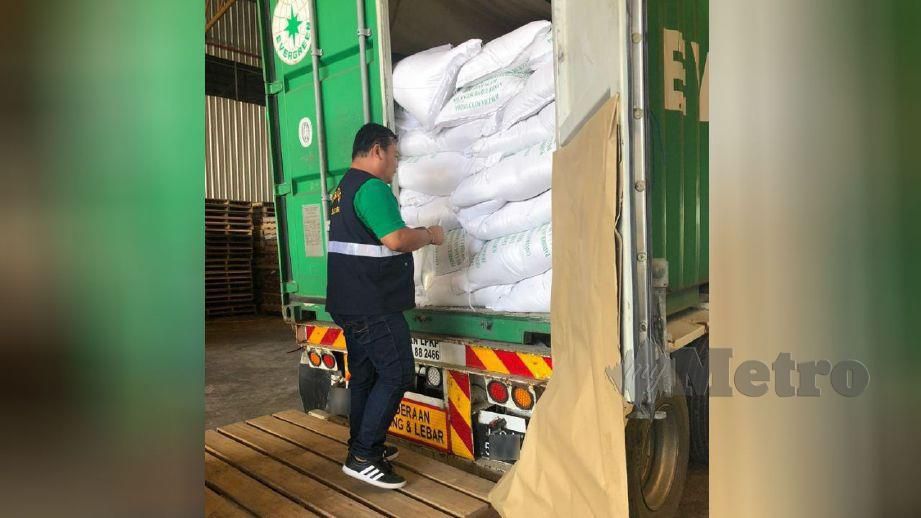 PENGUAT KUASA KPB memeriksa beras yang masih berada di dalam kontena di Bintulu, Sarawak. FOTO ihsan KPB