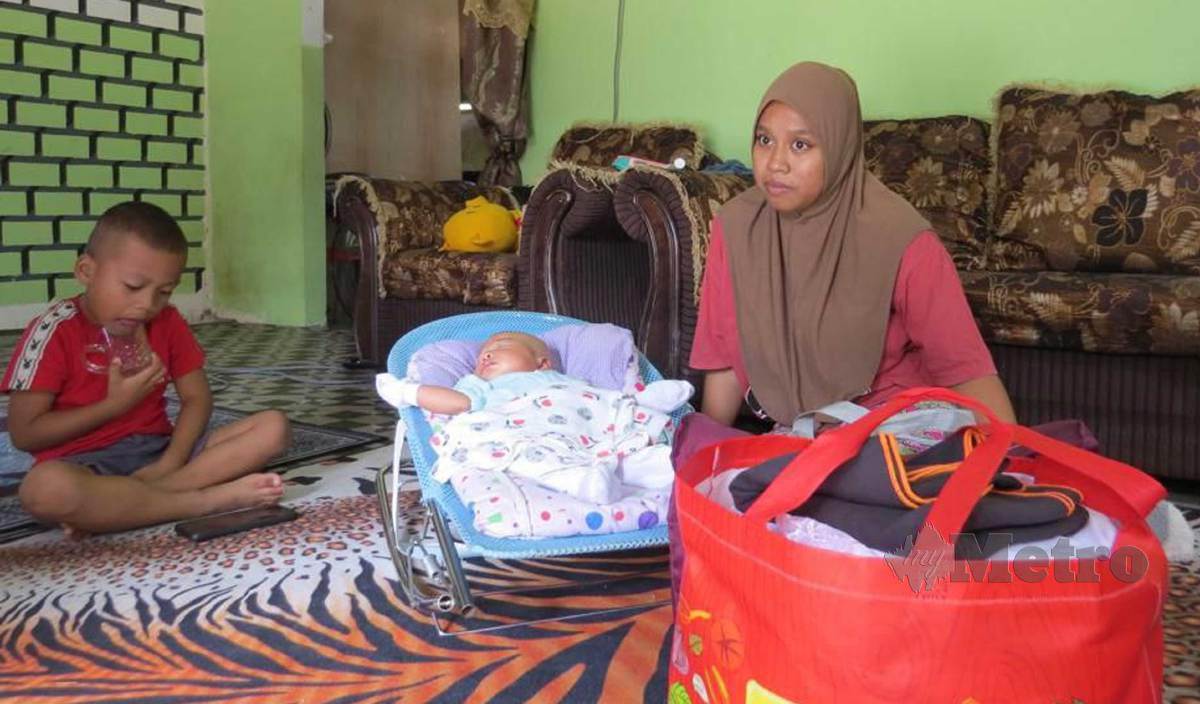 NOR Aini Azmira bersama bayinya ketika ditemui dirumahnya di Kampung Limau Kasturi. FOTO Paya Linda Yahya