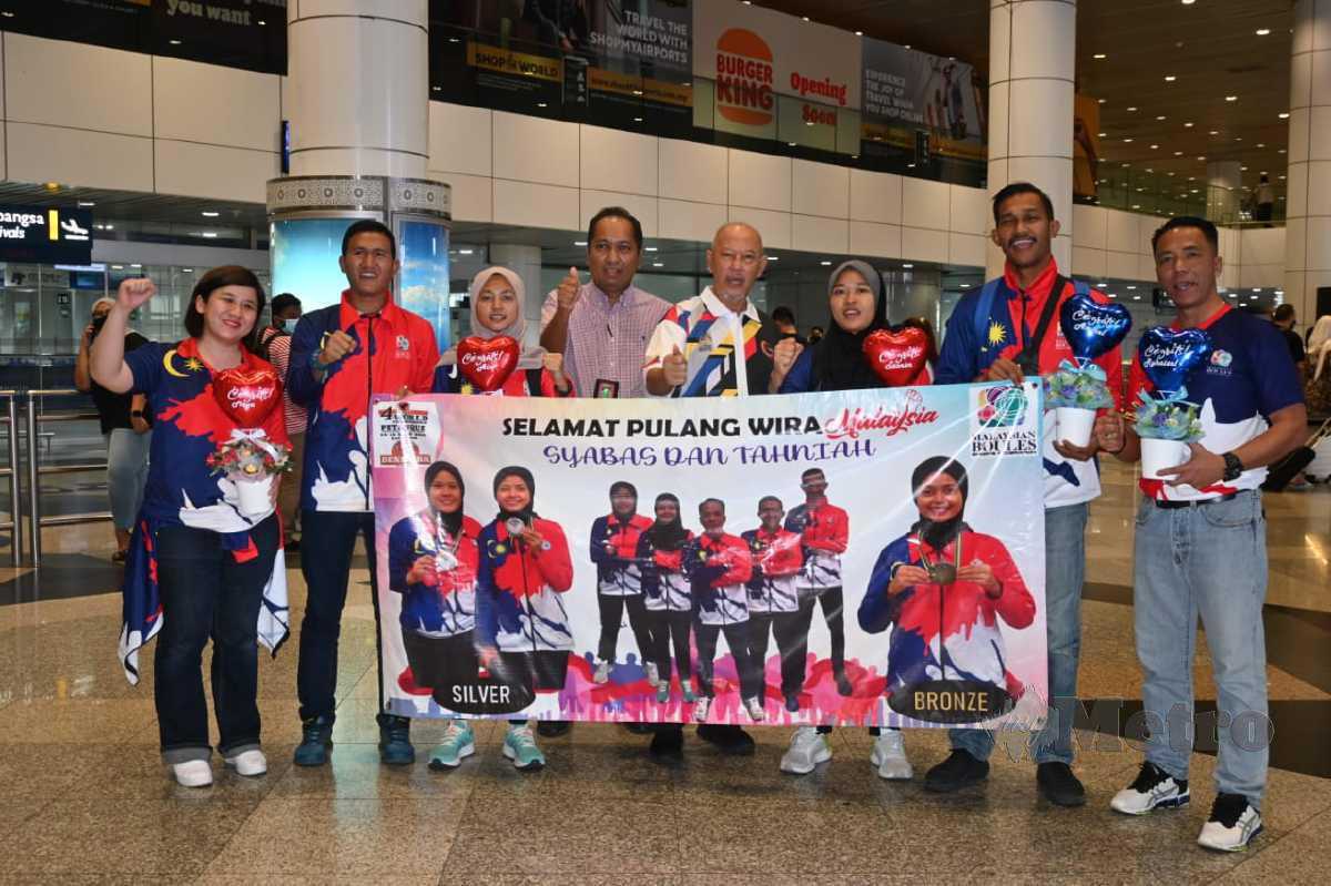 NUR Ain Syuhada (tiga dari kiri) dan Nur Thahira Tasnim (tiga dari kanan) diraikan ketika tiba di Lapangan Terbang Antarabangsa Kuala Lumpur (KLIA), semalam. FOTO Ihsan Malaysian Boules Sports Federation (MBSF)