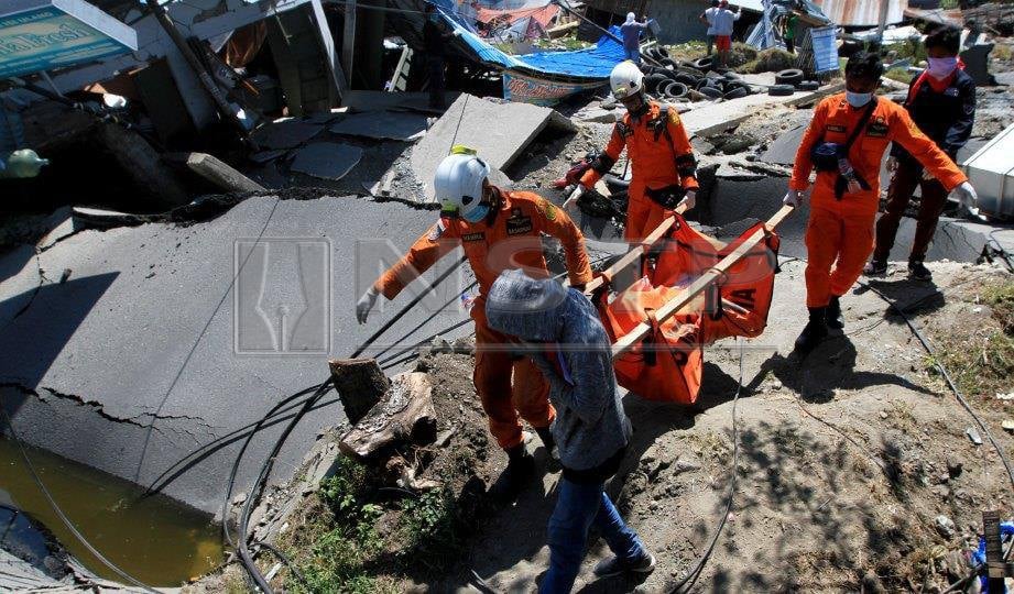 PASUKAN penyelamat mengangkat mayat penduduk. FOTO Reuters
