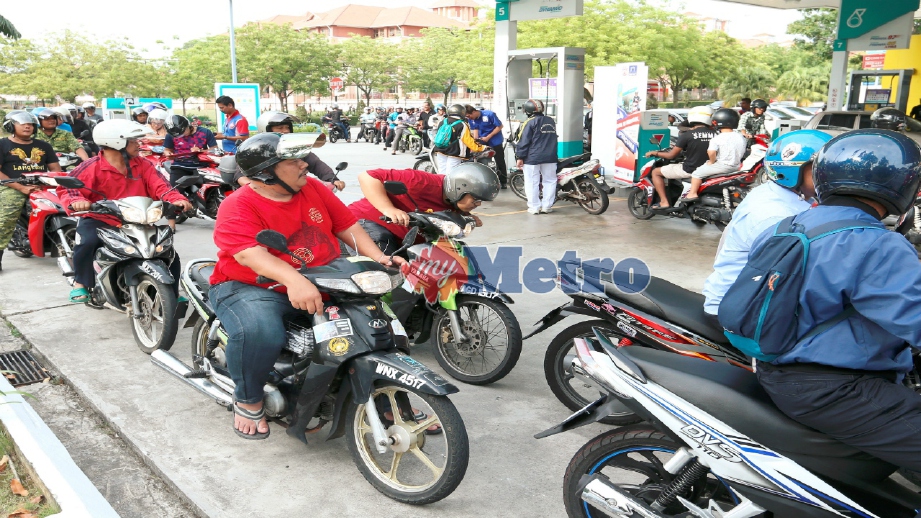 PENUNGGANG motosikal beratur untuk mengisi petrol pada program Jom Isi Minyak Percuma di stesen minyak Petronas Presint 9, Putrajaya, hari ini. FOTO Ahmad Irham Mohd Noor 
