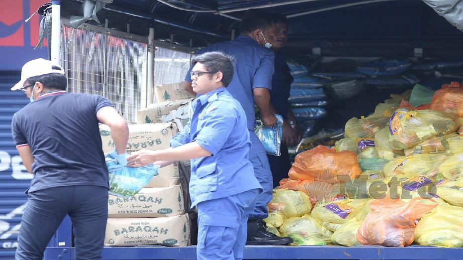 Petugas JKM memunggah barang makanan untuk diaghkan kepada penduduk sekitar Petaling Jaya Old Town di Jalan Othman yang dikenakan PKPD hari ini. Foto Fathil Asri 