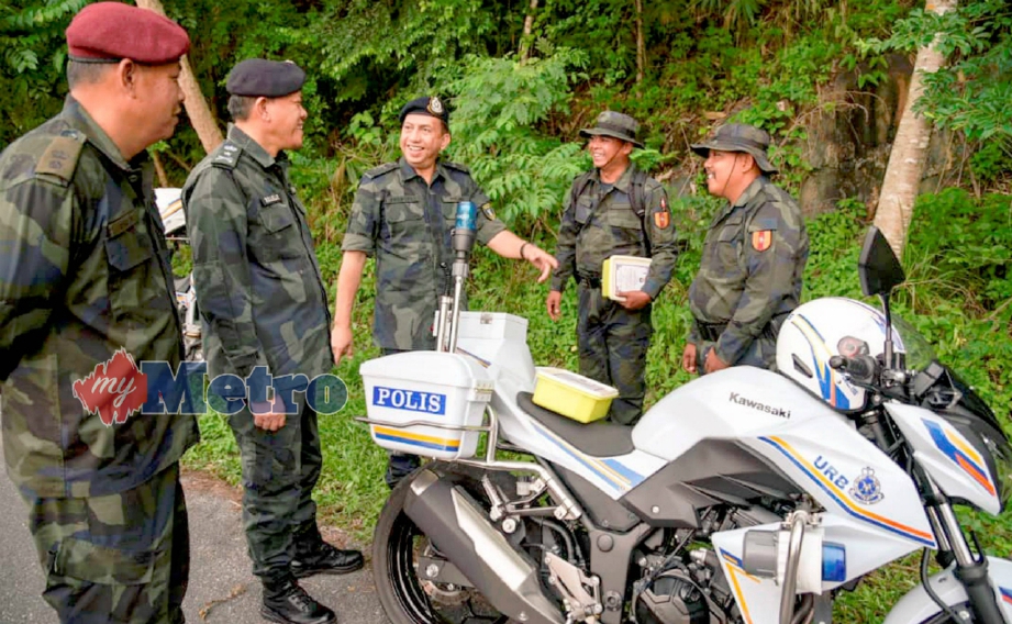 ZULKIFLI (tengah) beramah mesra dengan anggota Batalion Ke-18 PGA yang bertugas mengawal sempadan di laluan keselamatan menggunakan motosikal berhampiran Padang Besar sempena Ops Wawasan Kedah/Perlis, hari ini. FOTO Hafizudin Mohd Safar. 