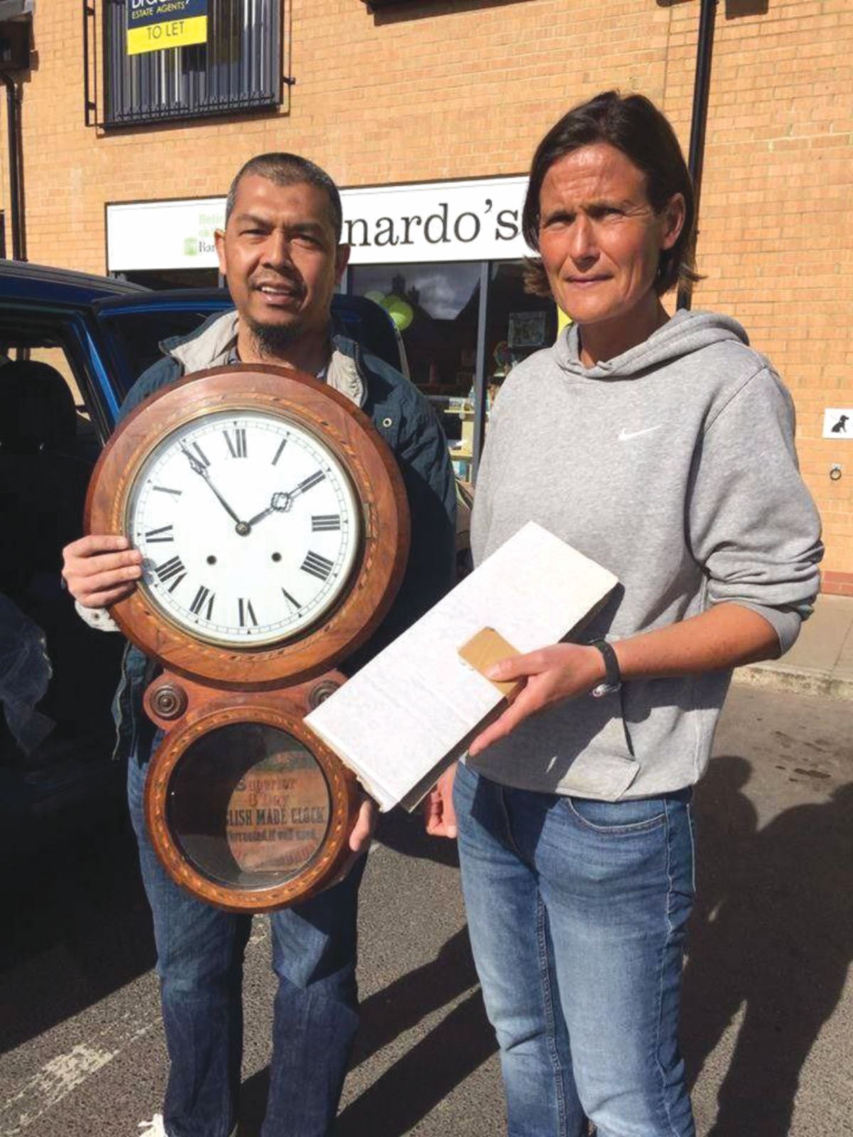 MOHD Borhan (kiri) ketika membeli jam antik daripada pemilik asal.