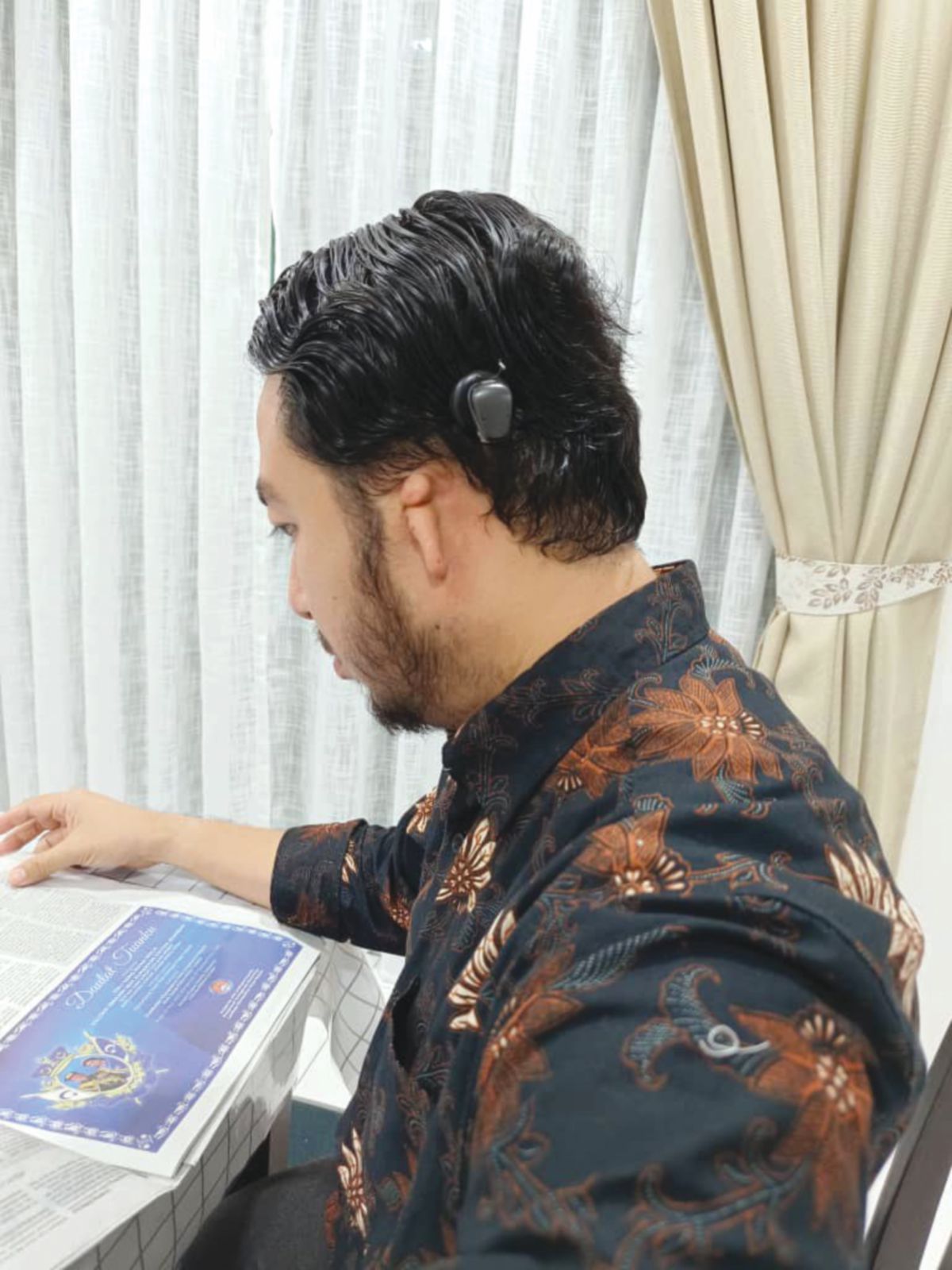 DR Mohamad Zarudin memakai alat bantuan pendengaran.