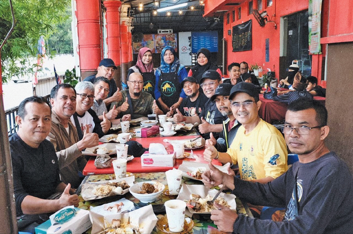 PENULIS (duduk empat dari kanan) bersama rakan dijamu Nasi Dagang Istana berhampiran Petronas Geliga, Kemaman. 